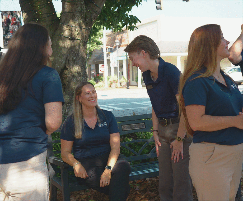 Heart City Marketing team members on a park bench in downtown Perry, GA