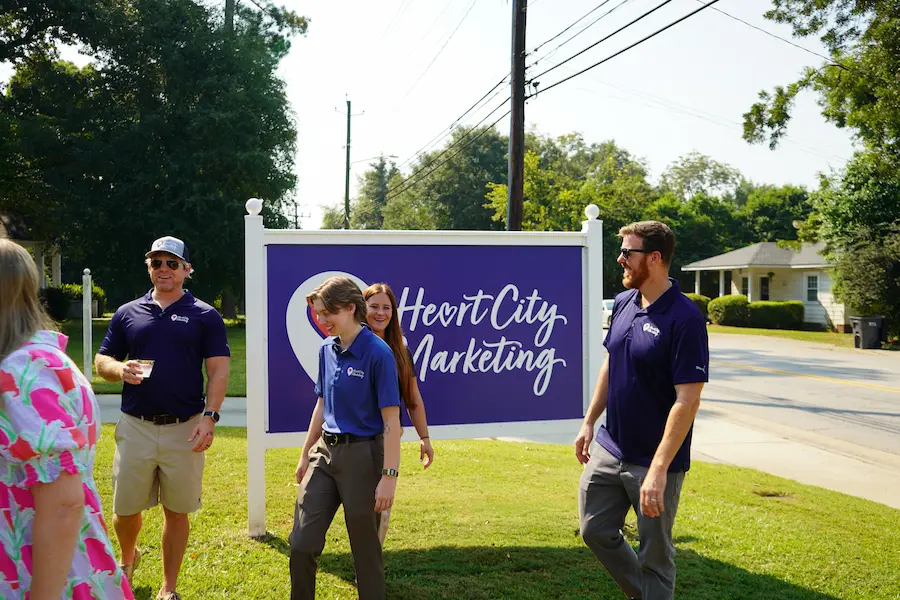 Heart City Marketing team candid photo in front of sign in Perry, GA